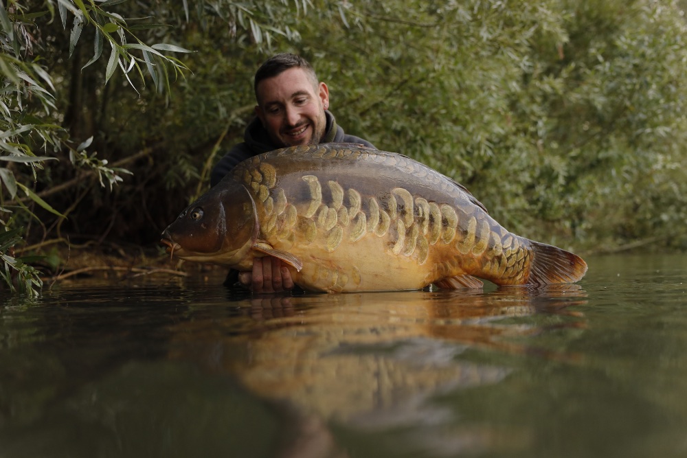 Pêcheur présentant une carpe du lac